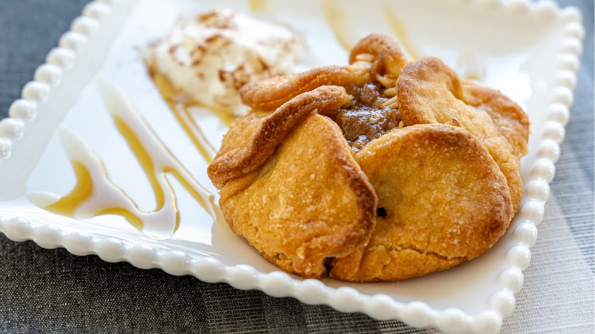 An apple blossom pastry with whipped cream and caramel